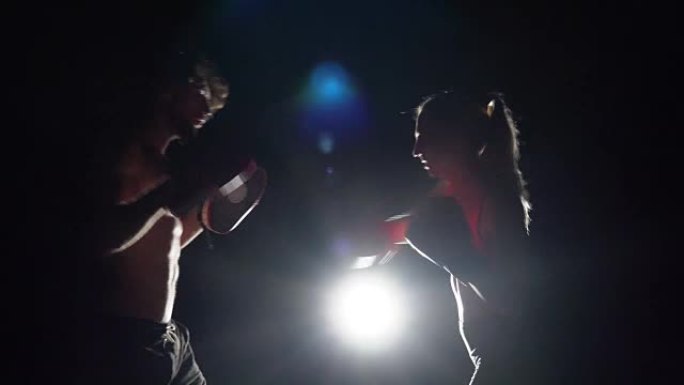 男女拳击手在拳击场上一起训练，直到打架。