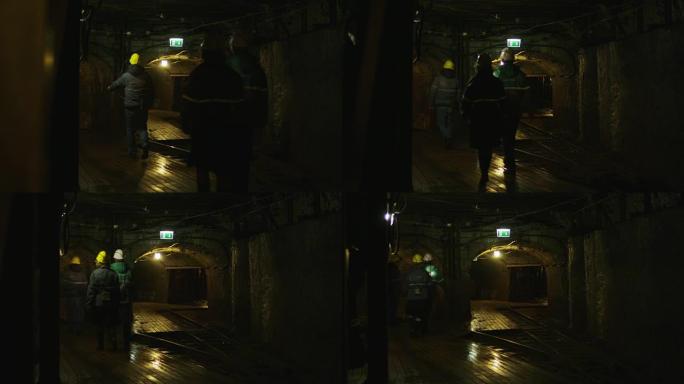 戴着安全帽的工人队伍正在采矿隧道中行走