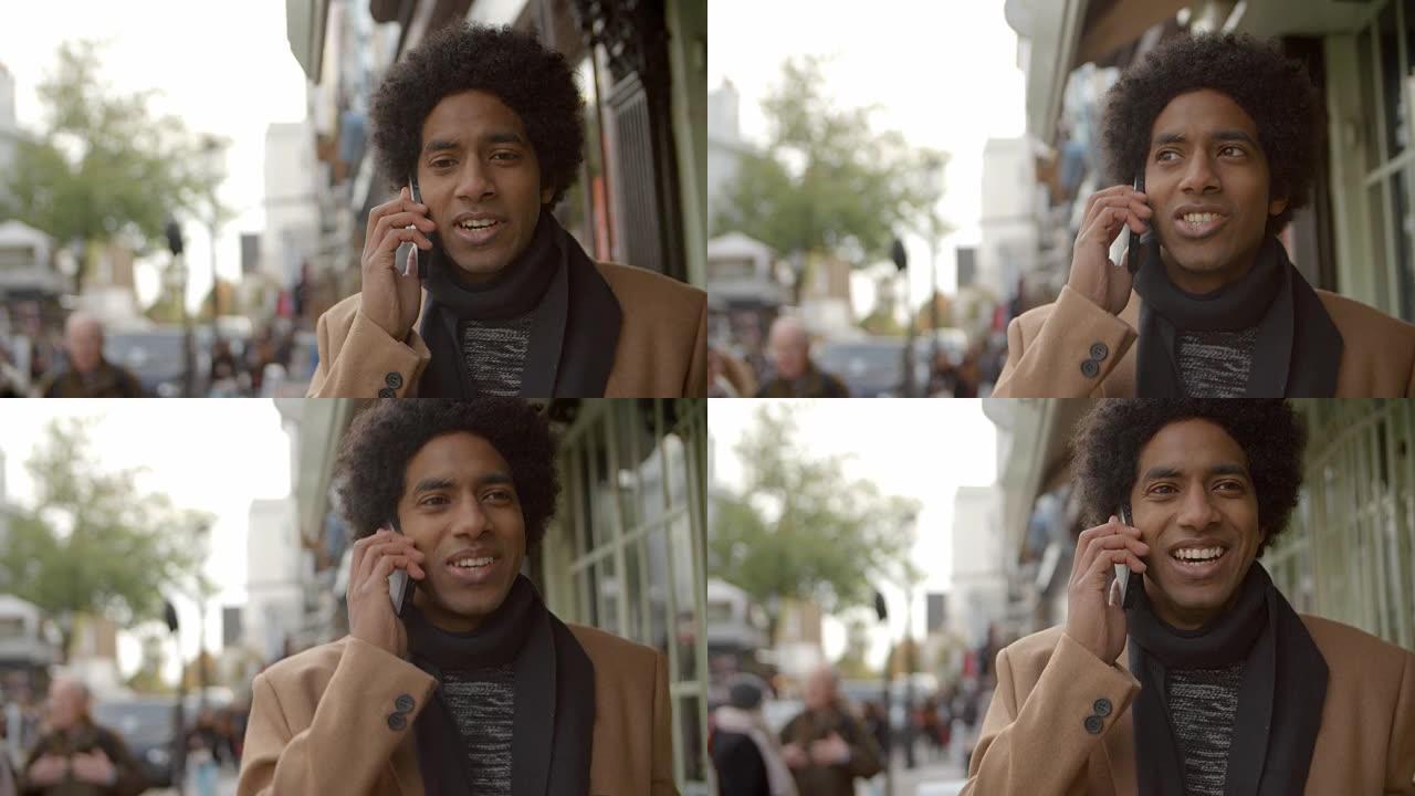 年轻人在繁忙的城市街道上行走时使用电话