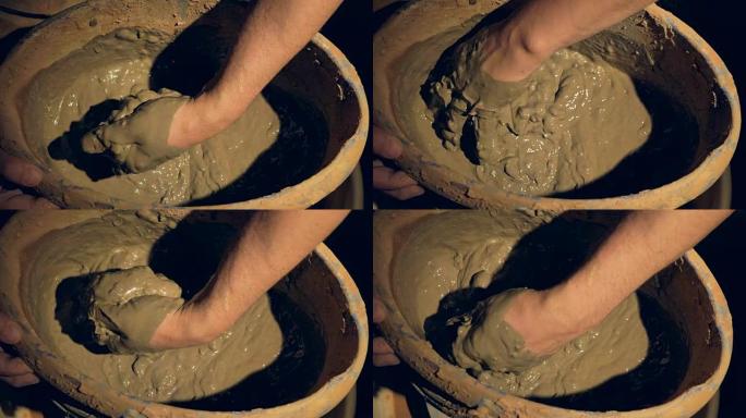 陶工手混合湿粘土的特写镜头。