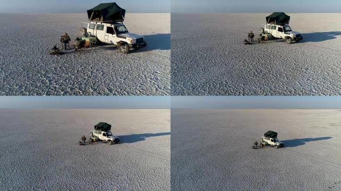 缩小在巨大的Makgadikgadi平底锅上露营的游客的鸟瞰图