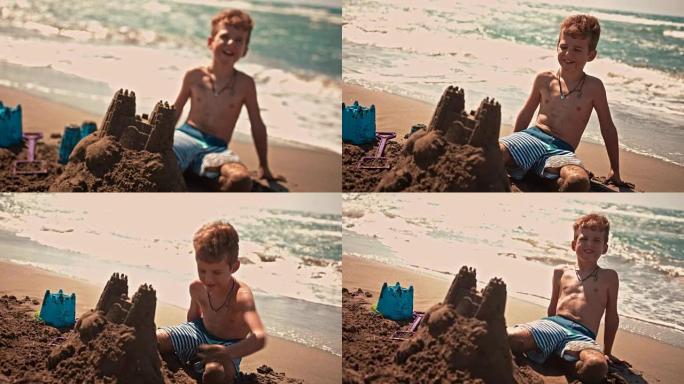 年轻的微笑男孩在夏天在海滩上建造沙堡