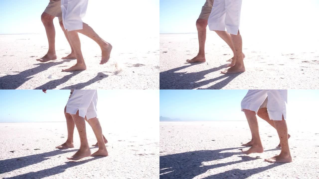 老年夫妇在沙滩上行走的腿和脚的特写