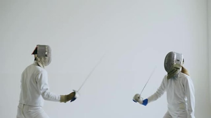 两名击剑手在白色背景的击剑训练中进行攻击和防御练习
