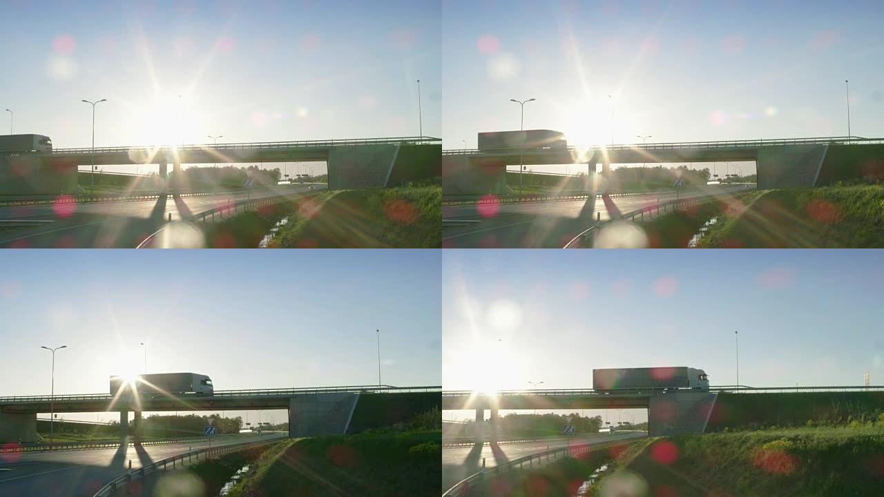 一辆白色半卡车的侧视图，带有货物拖车，驶过一座桥。美丽的风景，车辆在立交桥上行驶，阳光明媚，天空蔚蓝