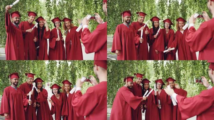 开朗的家伙正在使用智能手机为持有文凭的同学毕业生拍照，摆姿势并大笑。幸福、科技和教育理念。