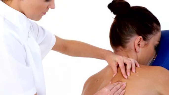 治疗师女性按摩患者背部的侧面视图