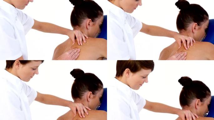 治疗师女性按摩患者背部的侧面视图