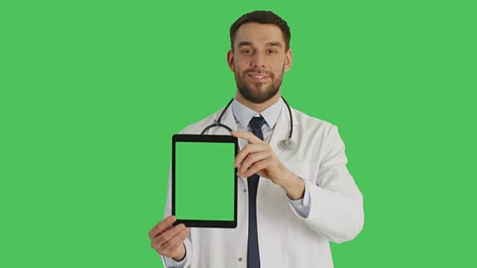 微笑的医生拿着绿屏垂直平板电脑的镜头。绿屏背景。
