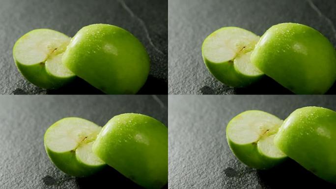 混凝土背景上的绿苹果减半4K