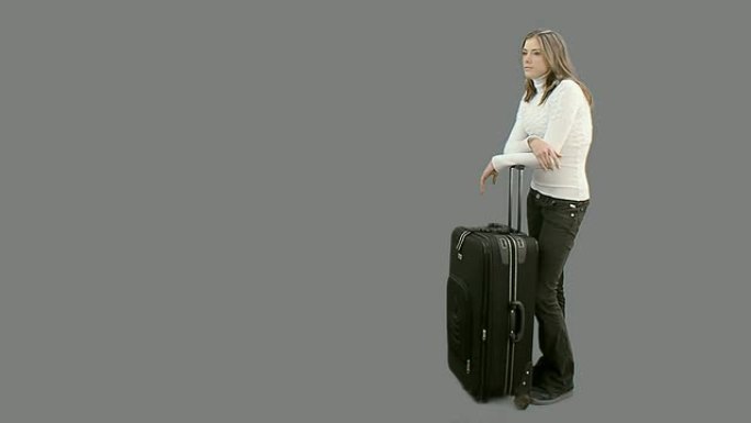 提着行李箱的女人在等她的同伴
