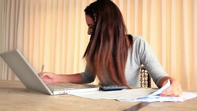 紧张的黑发女人用笔记本电脑解决她的财务问题
