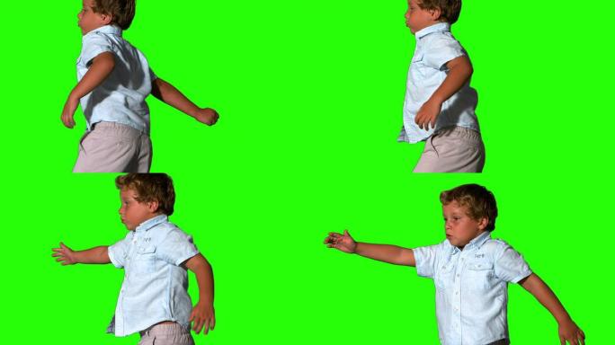 小男孩跳跃并打开绿色屏幕
