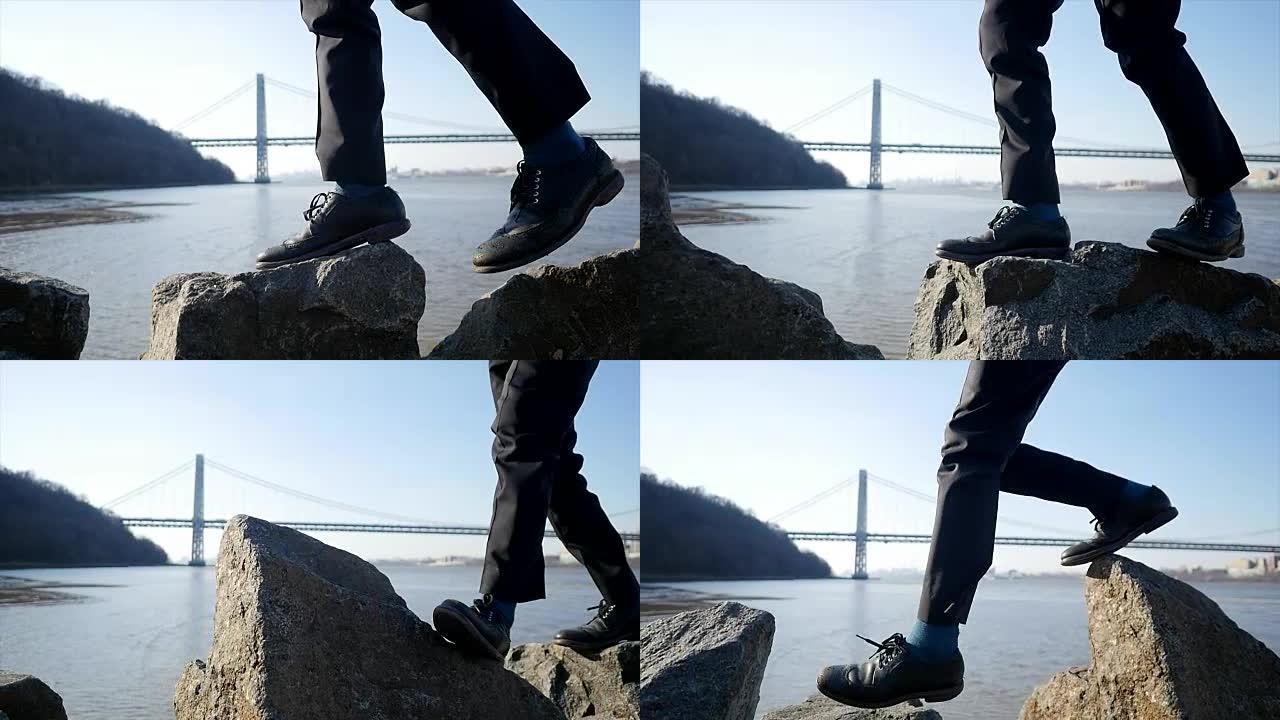 亚洲人独自站在海边的岩石上。走在石头。象征着成功、独立、克服障碍