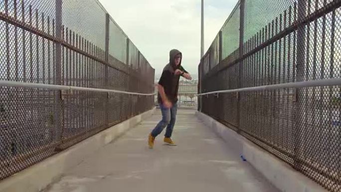 男子自由式嘻哈在城市的高速公路立交桥上跳舞