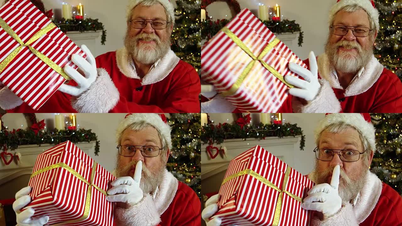圣诞老人拿着手指放在嘴唇上的礼品盒的肖像