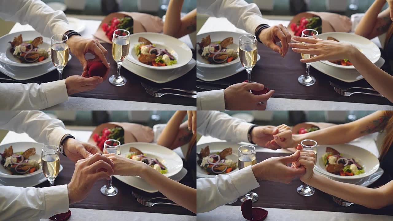 在餐厅浪漫晚宴上求婚时，美丽的戒指戴在女性手指上的特写镜头。参与和精致的餐饮概念。