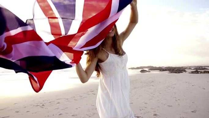 英国女子在海滩上与英国国旗一起奔跑