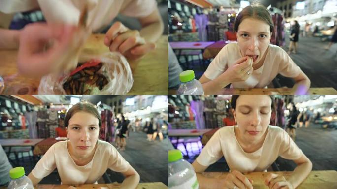 旅游妇女在街头美食亚洲餐厅吃蚕幼虫小吃的特写