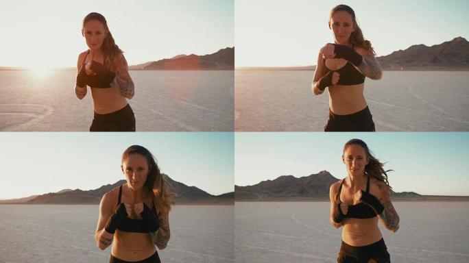 日落时分，在沙漠外拳击的女人对着镜头出拳