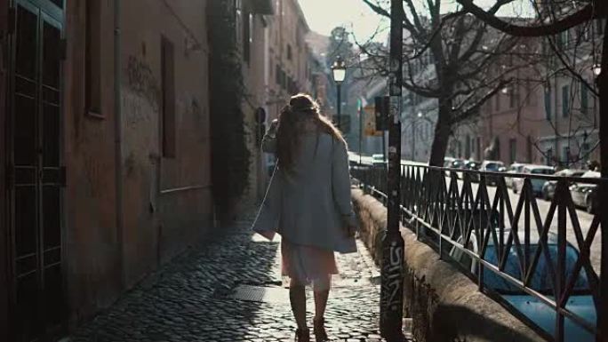 阳光明媚的日子里，长发的年轻女子走在街上。探索新城市的女游客