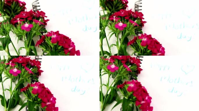 螺旋书上的粉红色花朵，带文本母亲节快乐信息