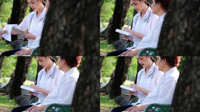 医生，护士，照顾老人一个女孩 (女人) 和祖父坐在平装本上看书，在公园里。概念寄宿房、疗养院、老人之