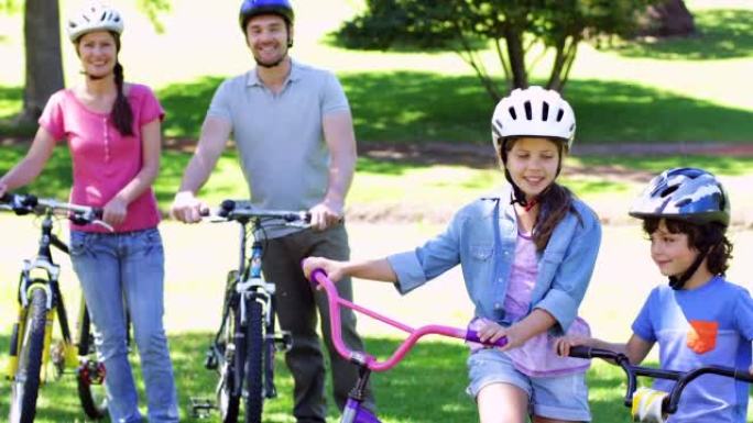 微笑的家人一起在公园骑自行车