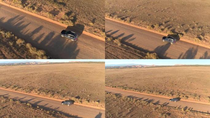 图片:一辆黑色SUV在日落谷尘土飞扬的路上行驶