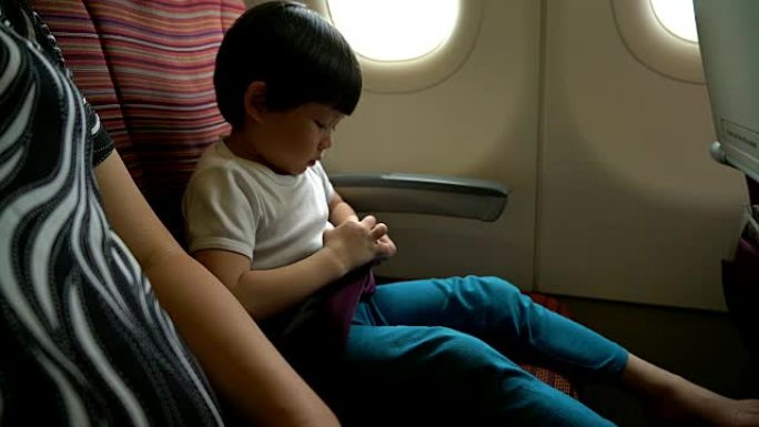 安全概念小男孩在飞机上系好安全带。