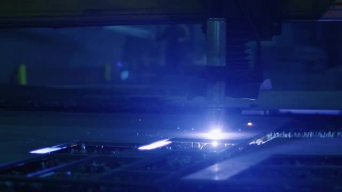 一台数控等离子切割机的特写镜头，该切割机正在一家重工业工厂切割金属物体。