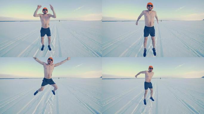 快乐休闲的男人在训练短裤在雪地上跳起来。