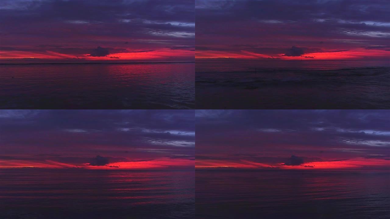 空中: 在法属波利尼西亚大溪地美丽的粉红色和红色日落下，在平静的海面上飞行