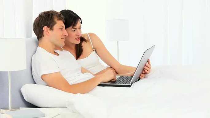 可爱的夫妇使用笔记本电脑