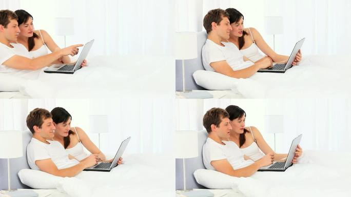 可爱的夫妇使用笔记本电脑