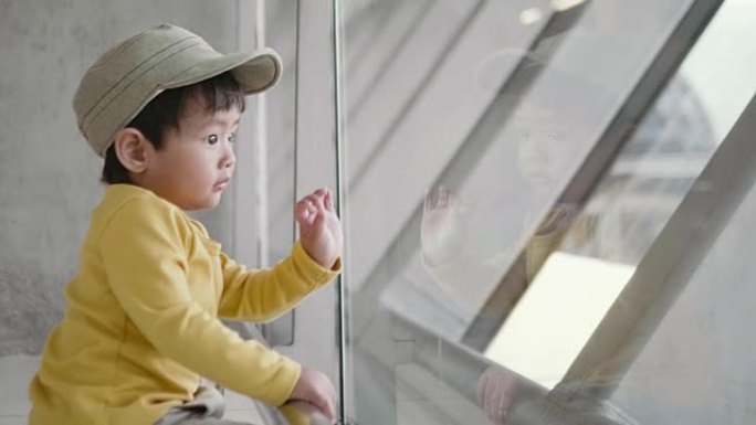 一个小男孩看着机场的飞机。