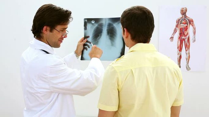 微笑的医生和病人一起看着x光