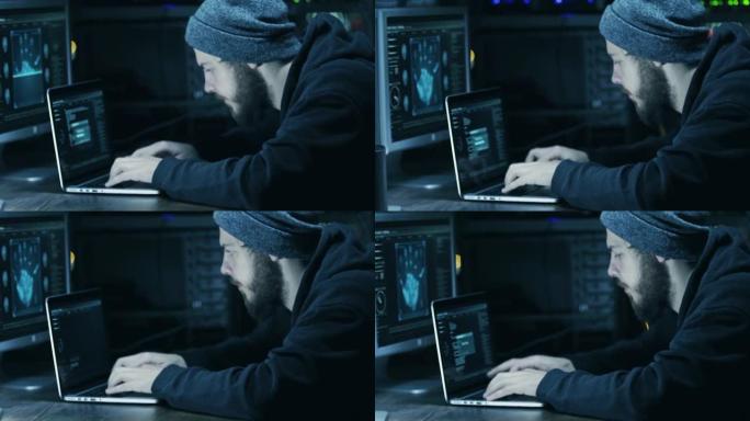 hood中的黑客使用黑暗的黑客房间中的笔记本电脑和计算机破解代码
