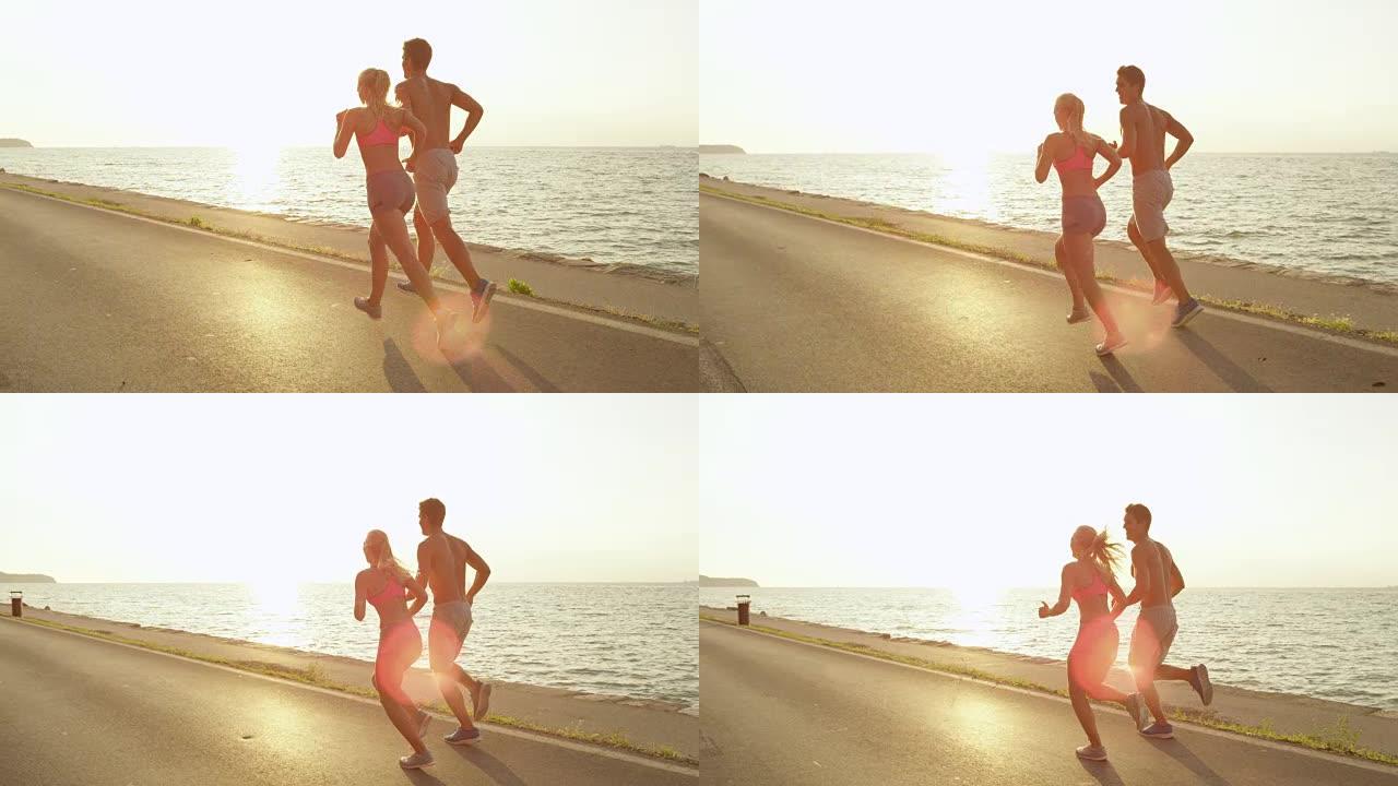 慢动作: 快乐的年轻夫妇在夏天的完美日子在海边慢跑