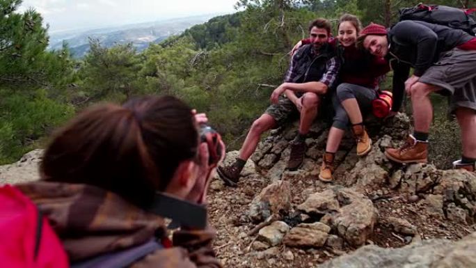 年轻的徒步旅行者朋友在山顶上拍照