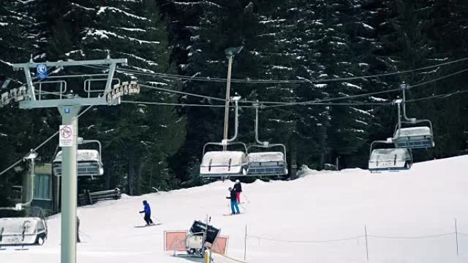 人们在升降椅附近的斜坡上滑雪