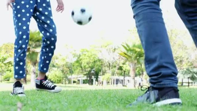 父亲和女儿在公园踢足球