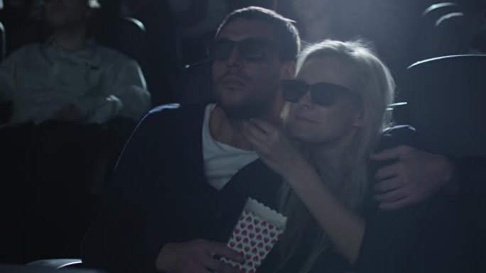 夫妻在电影院看5d电影放映时互相拥抱。