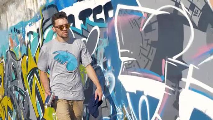 一位男性涂鸦艺术家沿着粉刷过的墙壁行走。