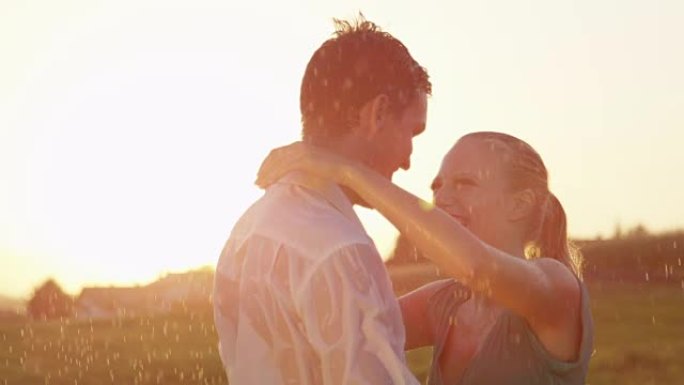特写: 在风景如画的夜晚，随和的年轻夫妇在雨中亲吻。