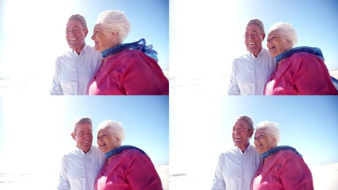 老年退休夫妇快乐地走在沙滩上