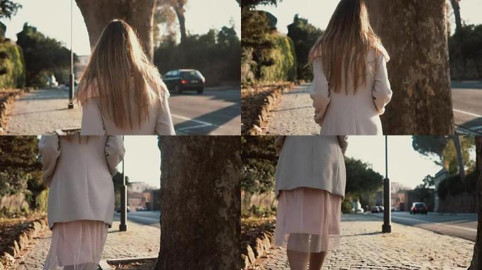年轻女子独自在市中心行走的背景图。忧郁的女性在阳光明媚的日子里靠近马路