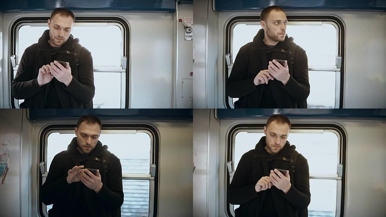 年轻有魅力的人站在地铁里，使用智能手机。英俊的男性在火车上上网