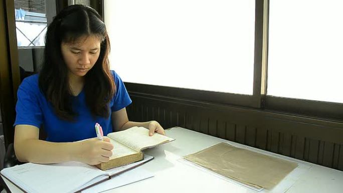 泰国女学生在笔记本上写了一张短纸条。