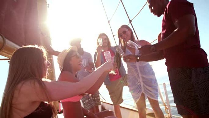 混合的朋友在游艇上喝带有sunflare的香槟